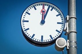 round street clock on a railway platform