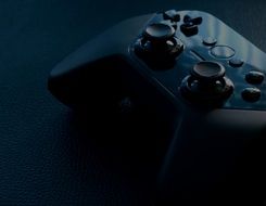 photo of a black game joystick on a black table