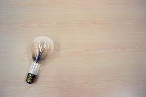 Dimmed Light Bulb at wooden background