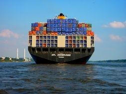 cargo Ship with colorful Containers on board on water