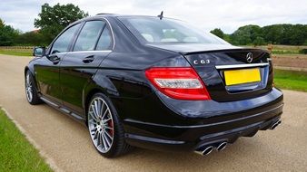 side view of a luxury black Mercedes on the road