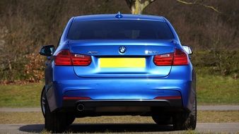 rear view of a luxury blue car on a sunny day