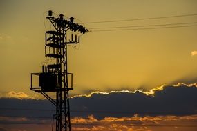 high-voltage tower on a background of golden sunset