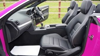 Black interior of a luxurious pink car