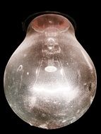 switched on light bulb on black