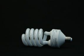 white energy-saving light bulb on a black background