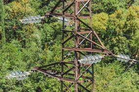 fragment of Power tower above green forest