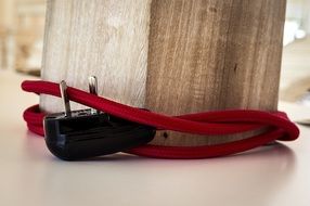 red electric cable around a wooden pillar