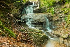 waterfall among stones in green moss