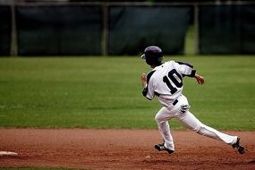Baseball runner on the green field