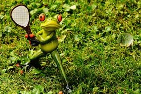 figurine of a frog with a racket in his hands