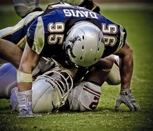 soccer player knocked down another player on the field in american football