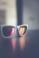 white framed female Sunglasses on table