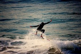 surfer in a black suit caught a wave in the ocean