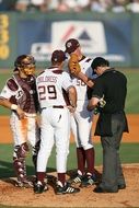 texas baseball team players with coach discuss strategy