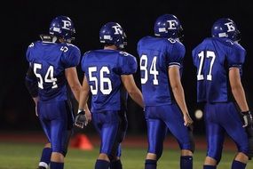 four american football players in blue uniform