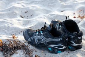 black jogging shoes on a sandy beach