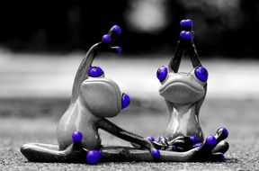Black, white and blue ceramic frogs doing gymnastics