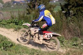 motocross on a dusty track among nature on a sunny day