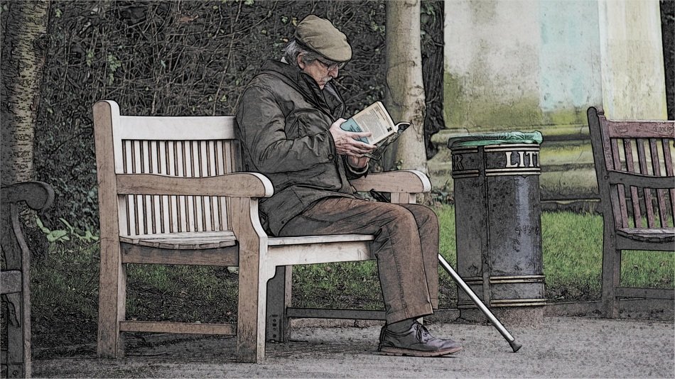 Man is reading a book on the bench