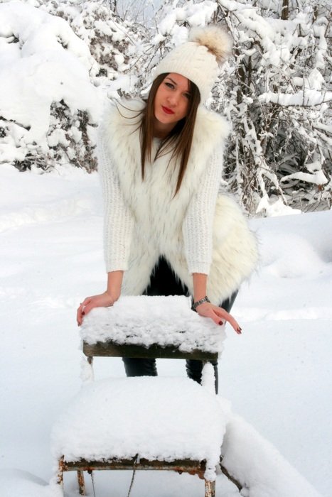 girl in white posing among deep snow