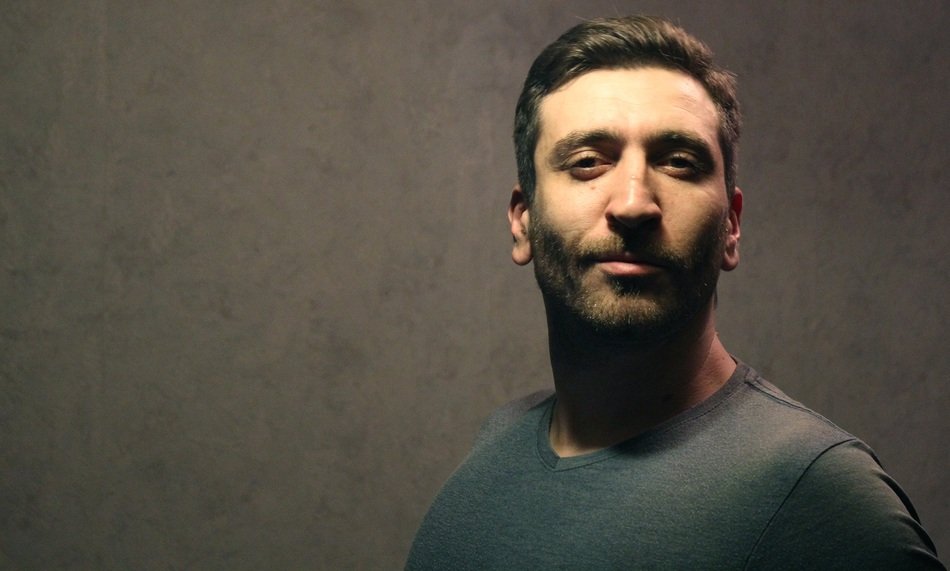 unshaven man near the wall