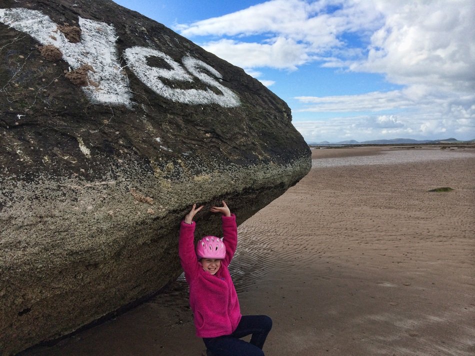 little girl holding a big stone