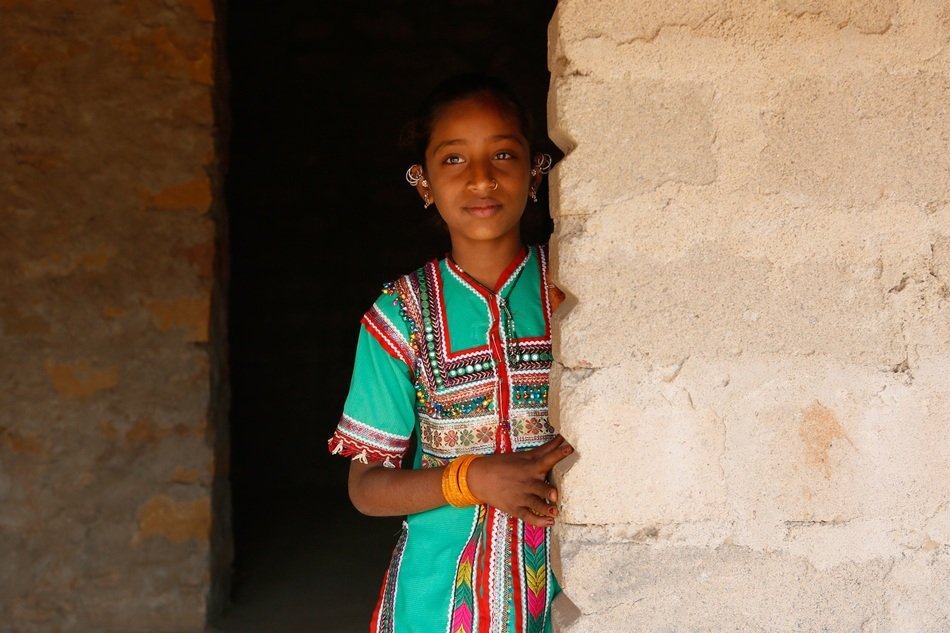 young hindu behind a stone wall