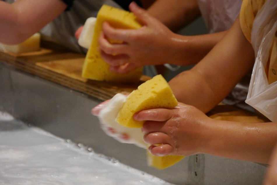 Soap and sponge in childâs hands