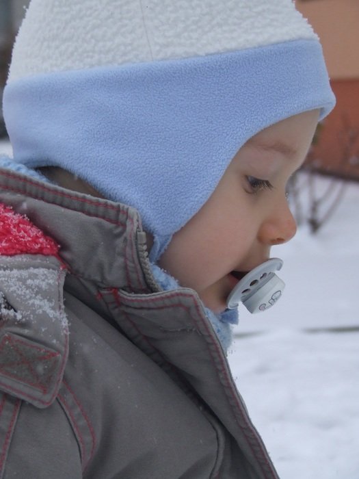 Small Child with pacifier outdoor at Winter