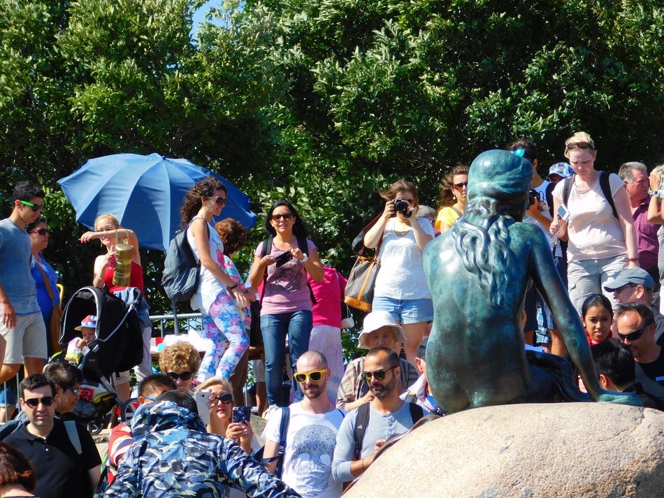 people near the little mermaid statue in copenhagen