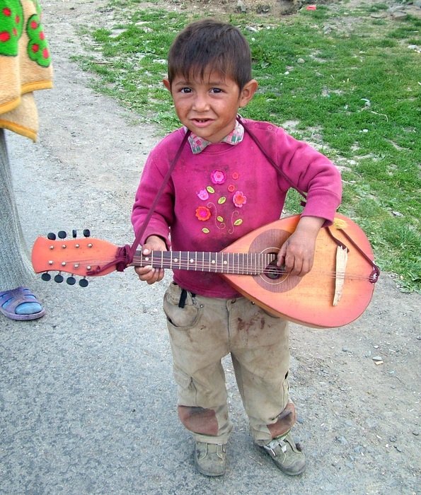 Baby gypsy with a guitar in his hands