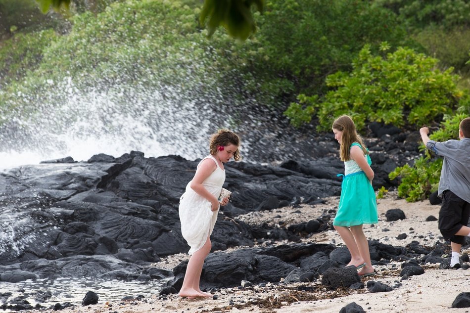 little girls among spray on tropical beach