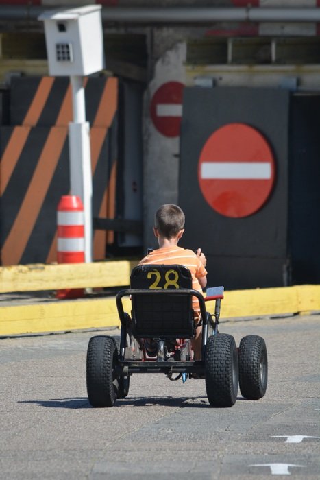 child on kart on the road with signs