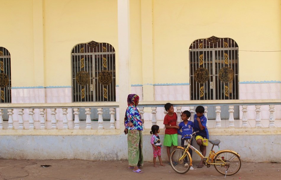 poor family on the background of a mosque in Cambodia