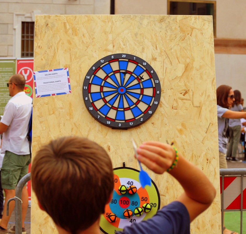 boy is playing darts on the street in Verona