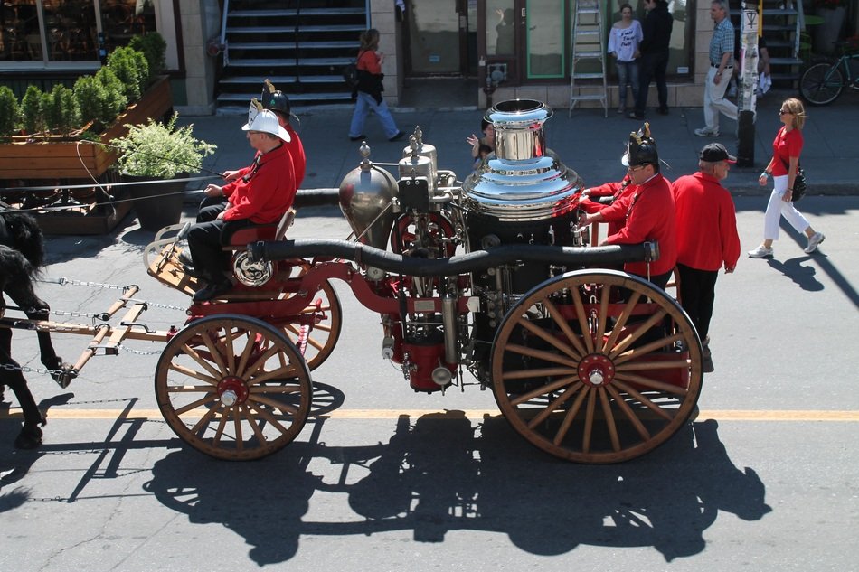 firefighters in old vehicle on parade
