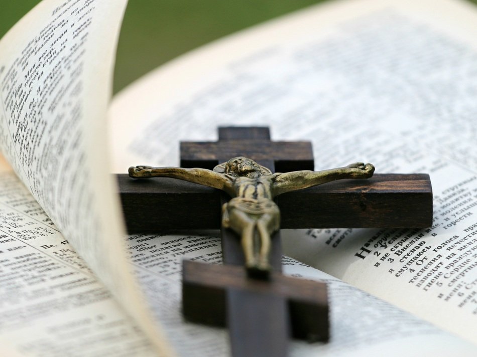 wooden cross lies on the bible