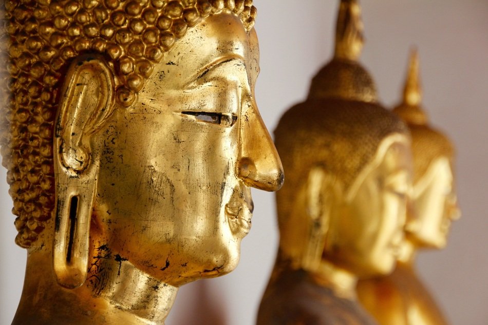 golden statues in a temple in bangkok close-up