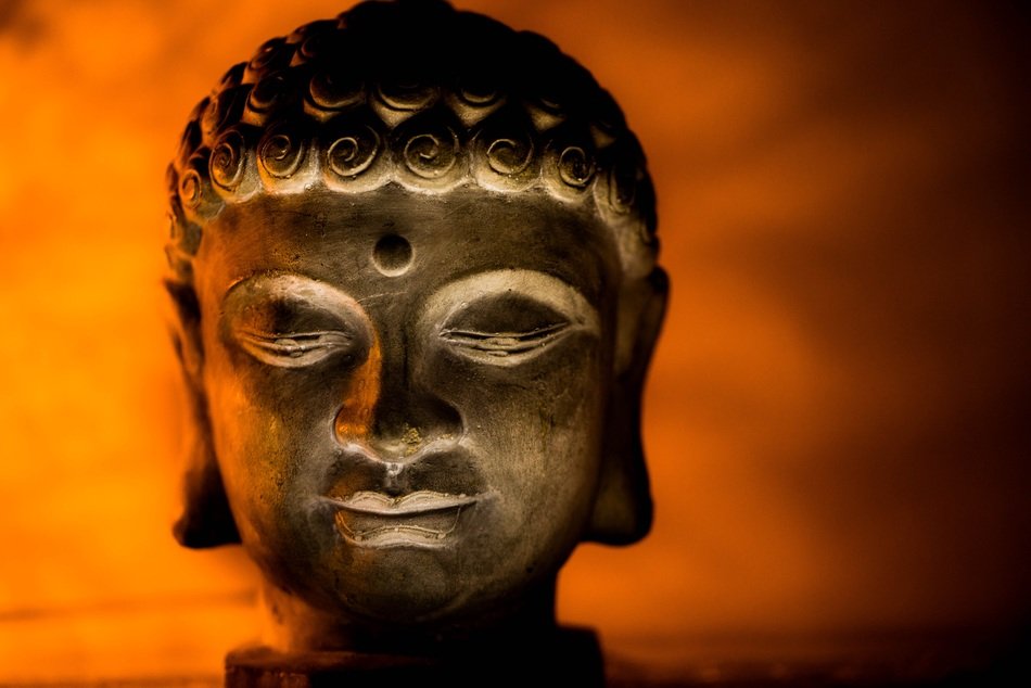 Head of Buddha statue on an orange background