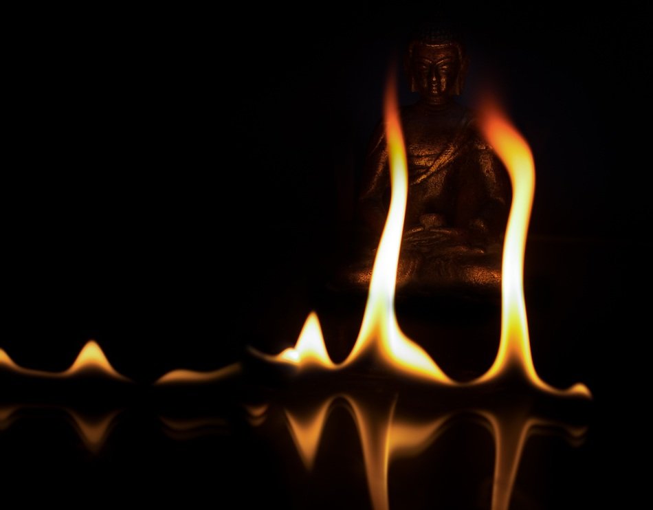 fire near buddha statue at dark background