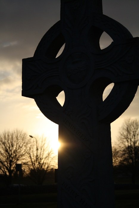 Celtic cross on a grave in the sunset