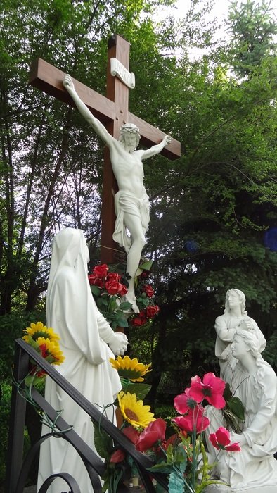 white statues and cross with the crucifixion of Jesus in the cemetery