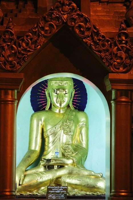 golden buddha statue in the red wall