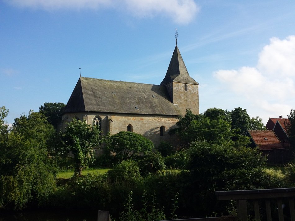 old church among green trees on a sunny day