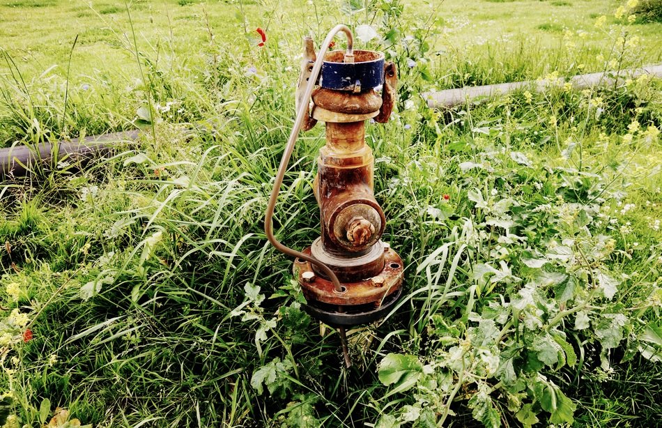 rusty water pump on the field