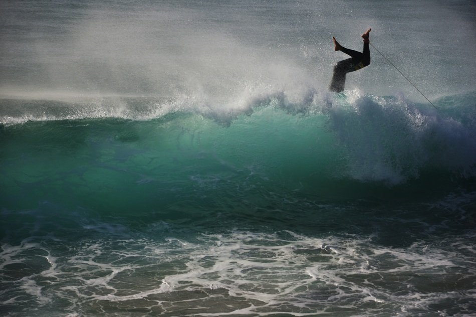 legs sticking out of a huge wave