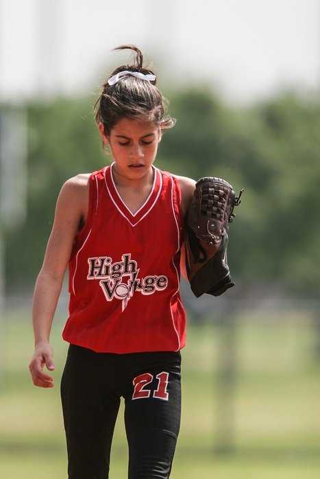 girl playing softball on the field
