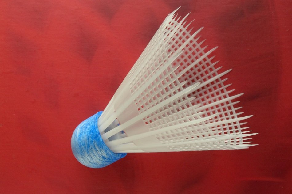 photo of a white shuttlecock on a red background