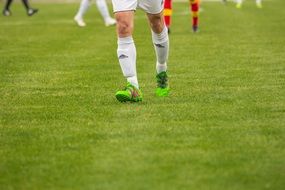 soccer player in green sneakers on the field